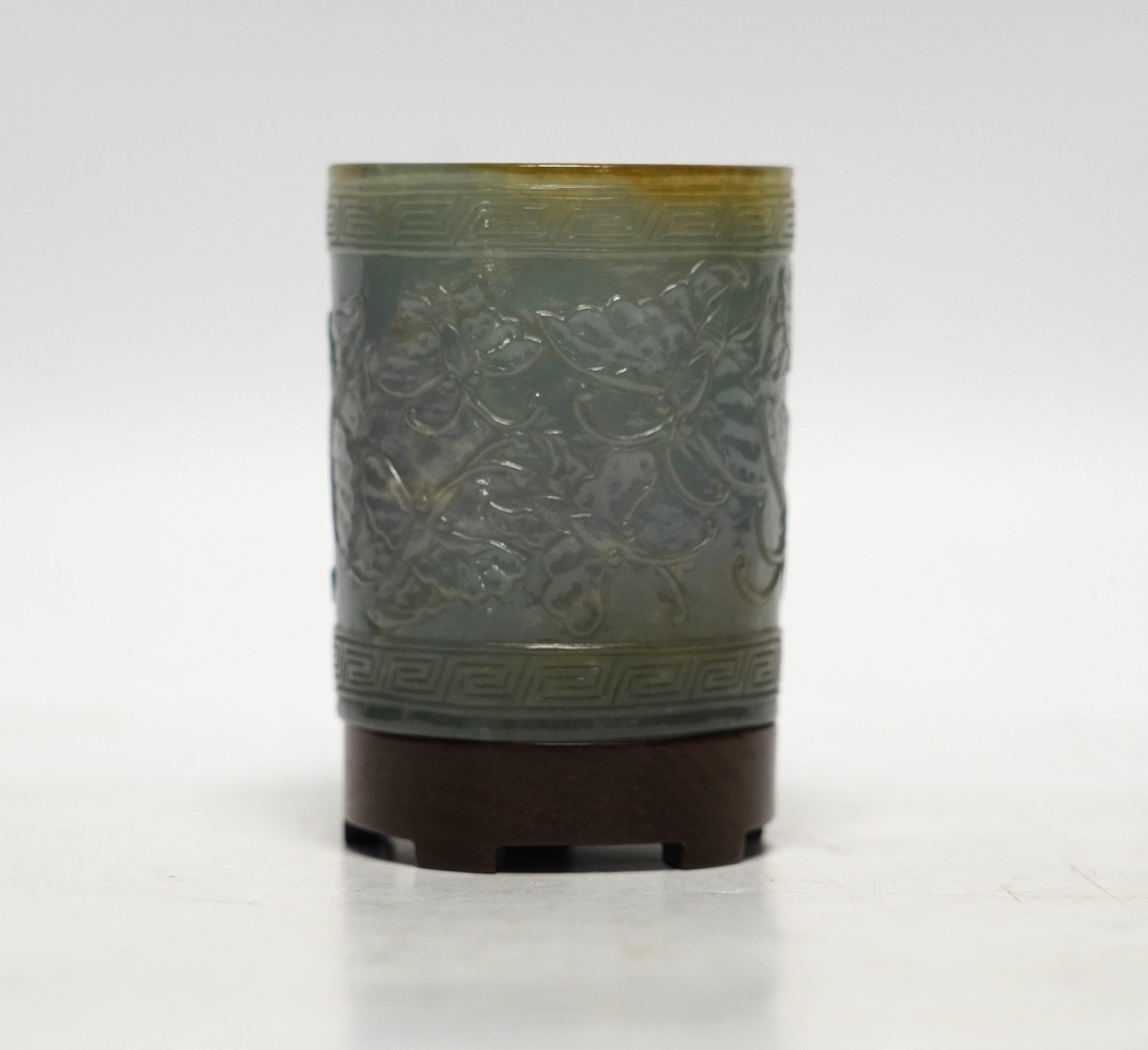 An early 20th century Chinese jadeite brushpot, 7cm high, on a hardwood stand